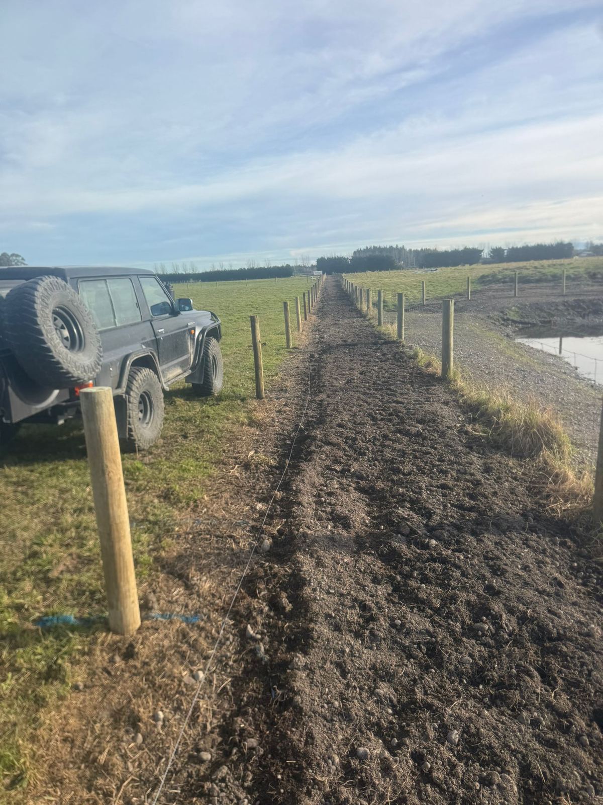 Stock fencing on timber posts, North Canterbury farmland behind